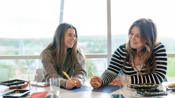 Studenter ler og smiler mens de jobber
