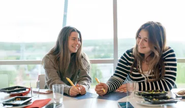 Studenter ler og smiler mens de jobber