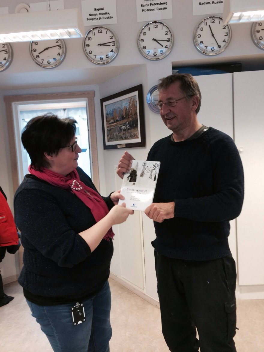 Bilde av to personer som holder en ny bok om reindrift.