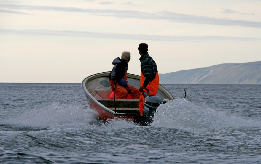 To personer i liten båt i en fjord.