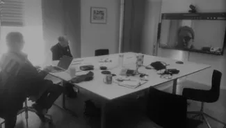 black and white photo of a person at a table having a video call