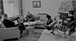 black and white picture of three people sitting across from each other in a sofa group